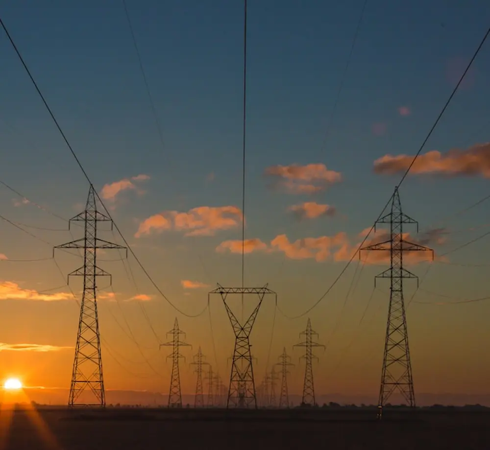 High-voltage power transmission towers at sunset