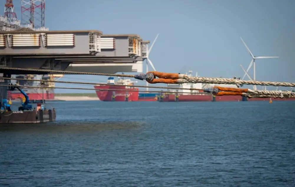 Cable being loaded onto an installation vessel at an industrial port
